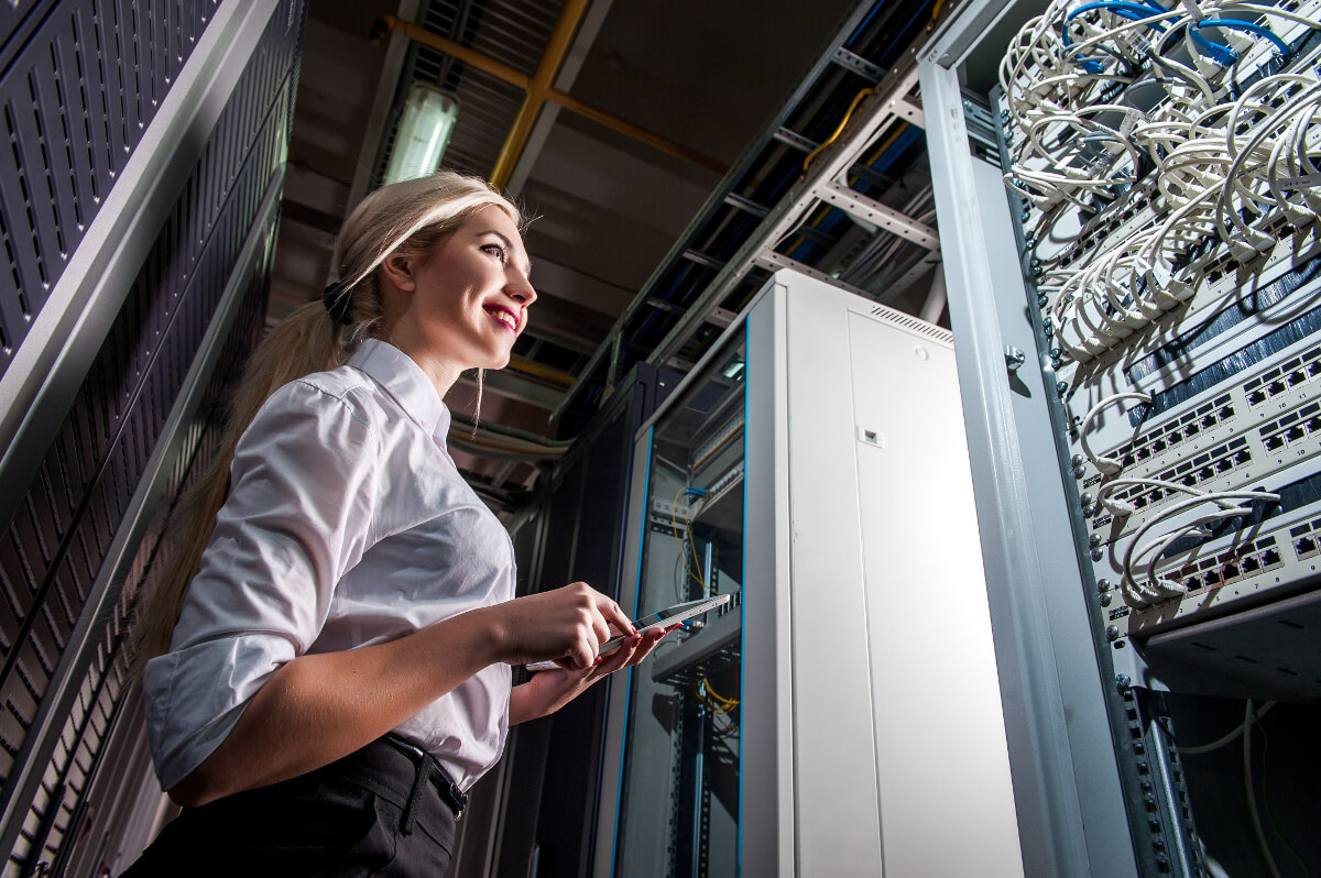 Female Technician Standing in Front of a Server Rack