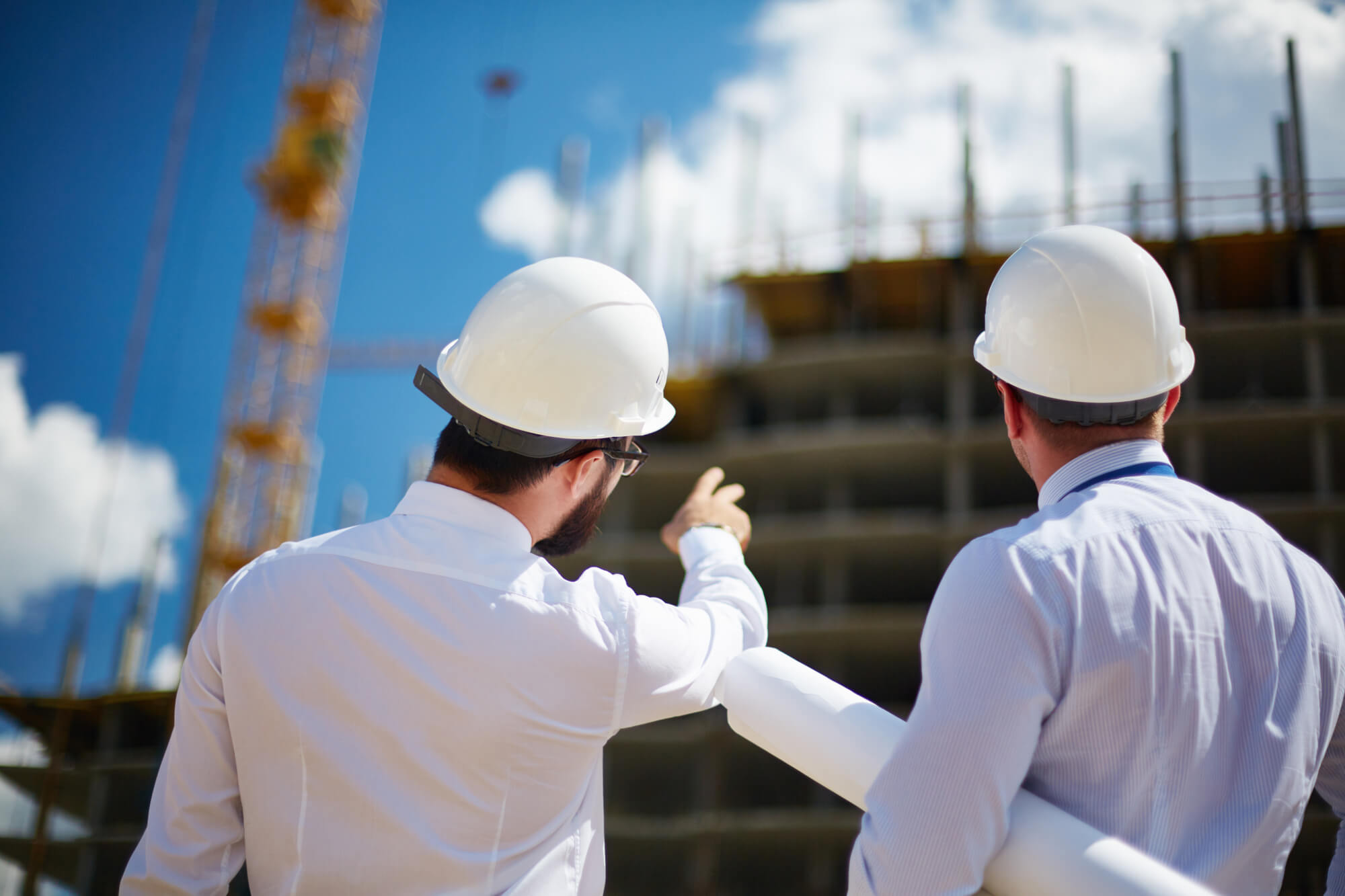 Two architects outside of a building being constructed