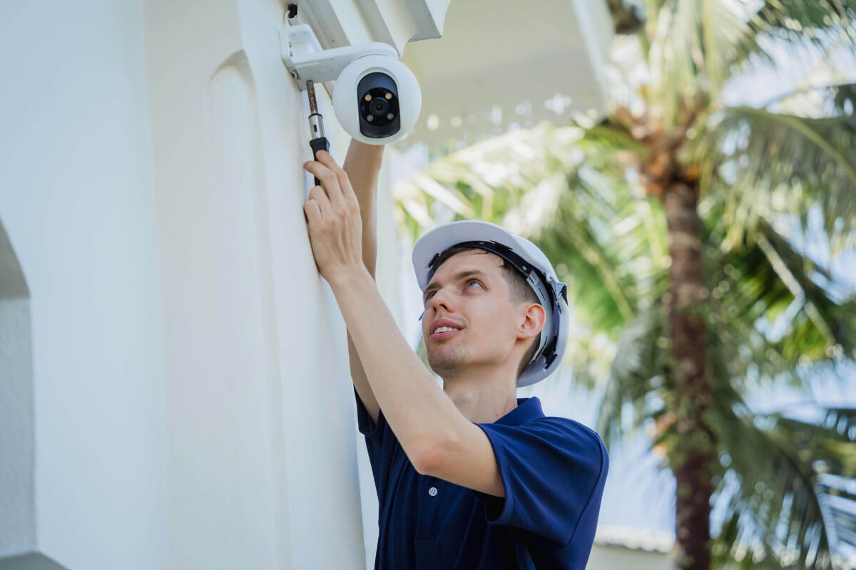 Technician installing a CCTV camera on the facade of a building