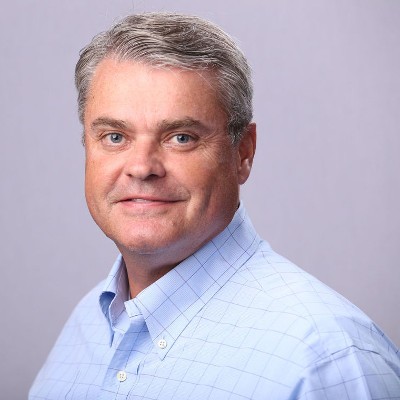 Pete Engle, President of Joy Communications, smiling and wearing a blue button down shirt